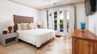 Bedroom with a woven strap headboard and glazed doors onto the pool, Sugar Cane Ridge 21 – Ruby Blue, Barbados luxury villa