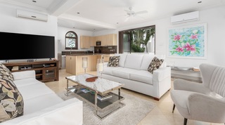 Open-plan living room and kitchen with batik hibiscus art at Tree House Villa 5, luxury villa in Barbados