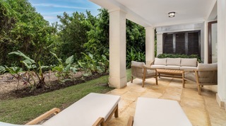 Teak garden seating and sun loungers on the lawn-edged lower patio at Tree House Villa 5 in Barbados