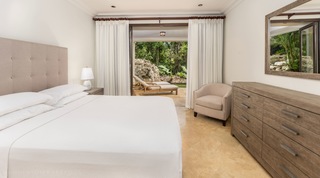 Tree House Villa 5's second guest bedroom looks out to sun loungers and coral rock planting, Barbados
