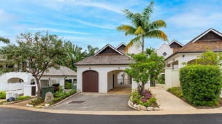 Gabled frontage and palm-shaded drive at Tree House Villa 5, a golf resort villa at Apes Hill, Barbados