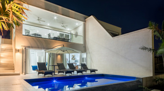 Glowing pool and sun loungers at twilight, Westmoreland Hills 25, holiday villas Barbados