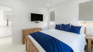 Natural wood king bedroom with ensuite glimpse at Westmoreland Hills 25, St. James, Barbados
