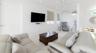Media lounge at Westmoreland Hills 25 with wall-mounted TV and twin sofas, St. James, Barbados
