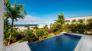 Infinity pool with tropical garden and sea beyond at Westmoreland Hills 25, barbados villa in St. James