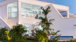 Dusk exterior with lit upper gallery and pool edge at Westmoreland Hills 25, a luxury villa in Barbados