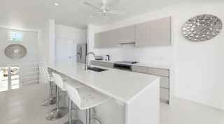 Bright kitchen at Westmoreland Hills 25 with white quartz breakfast bar and bar stools, Barbados